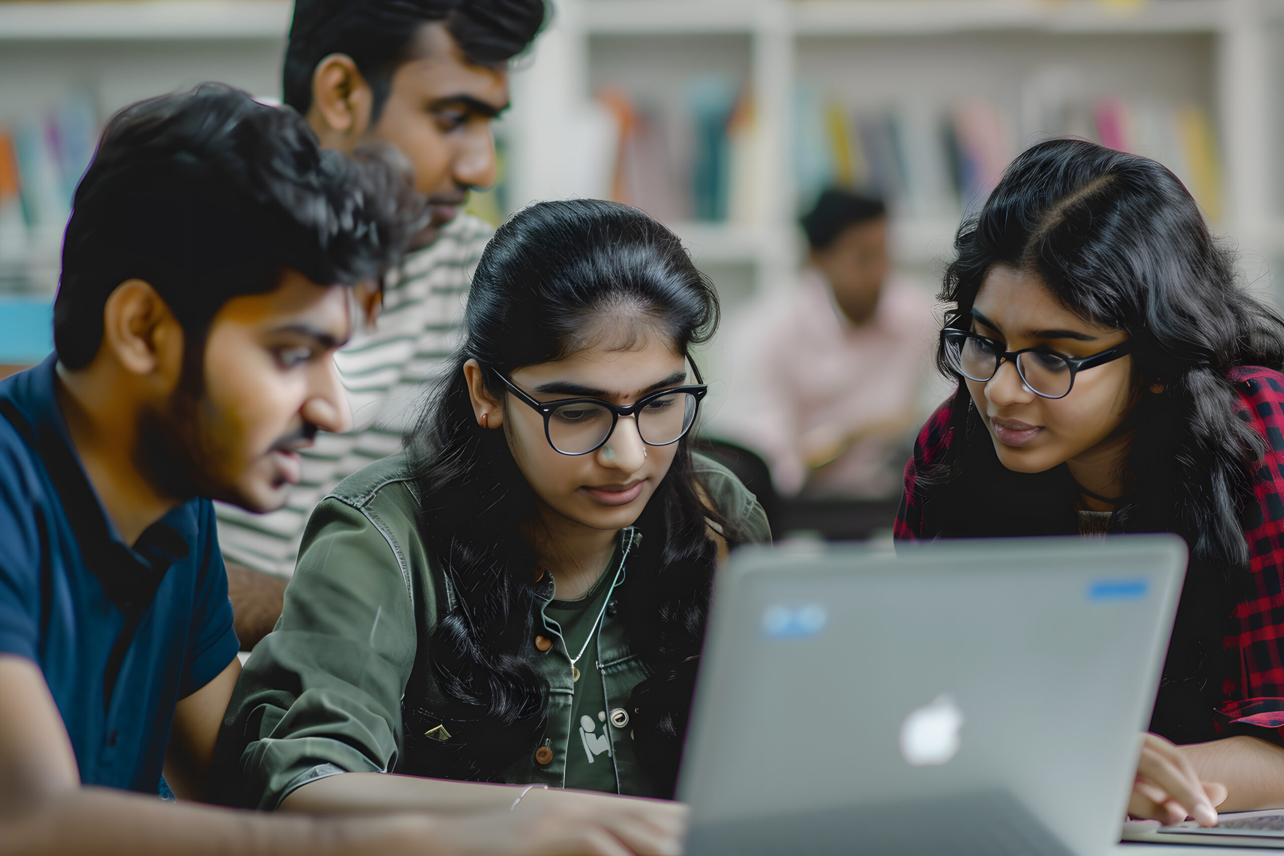 Group of young indian students using laptop computer and smiling at camera